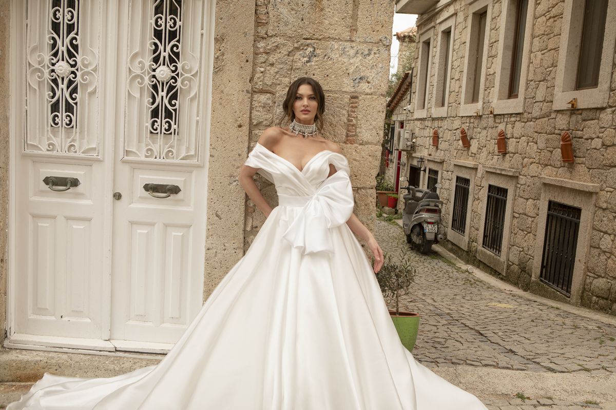 Satin white wedding gown Stella with a bow, off-shoulder sleeves and a-line skirt by Oksana Mukha designer 5