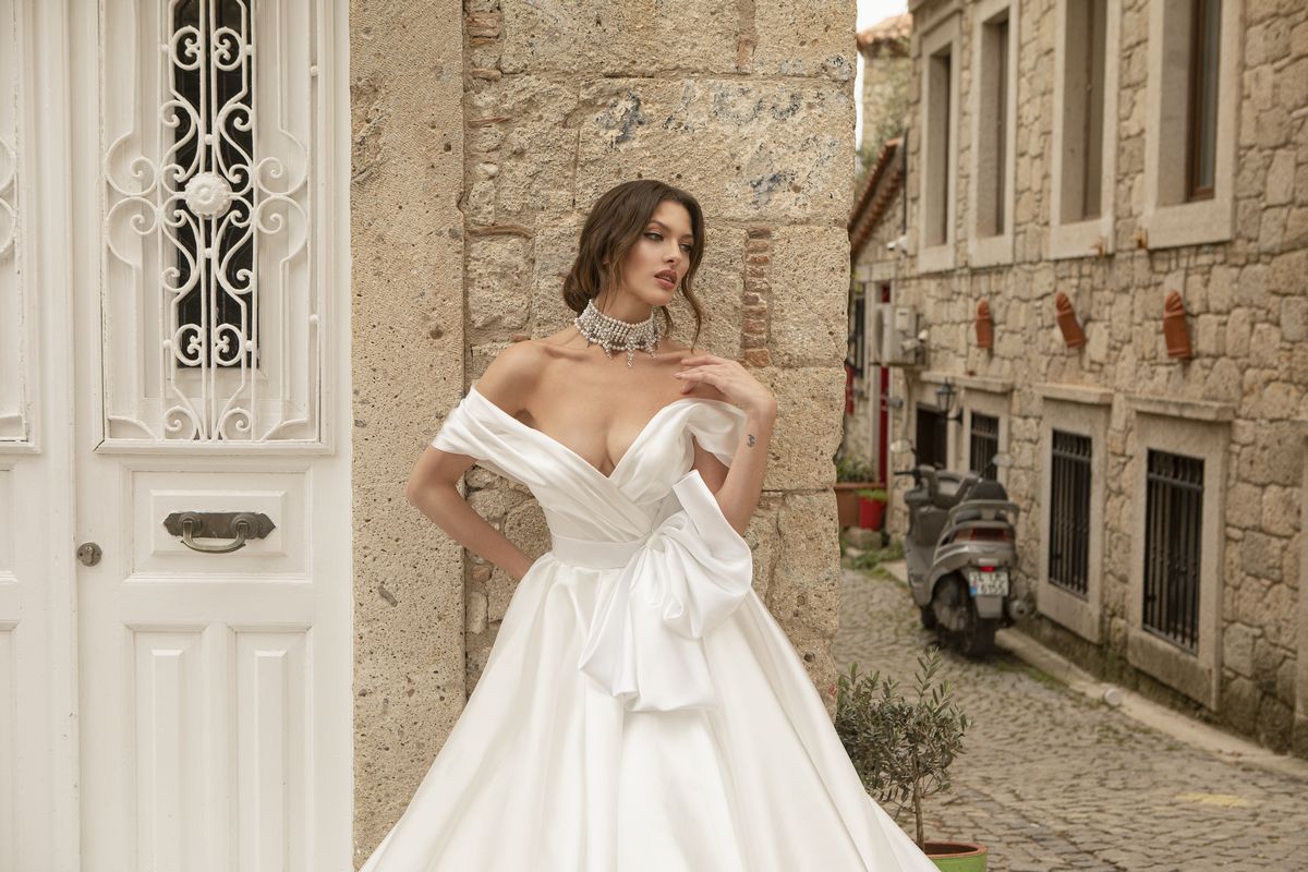 Satin white wedding gown Stella with a bow, off-shoulder sleeves and a-line skirt by Oksana Mukha designer 4