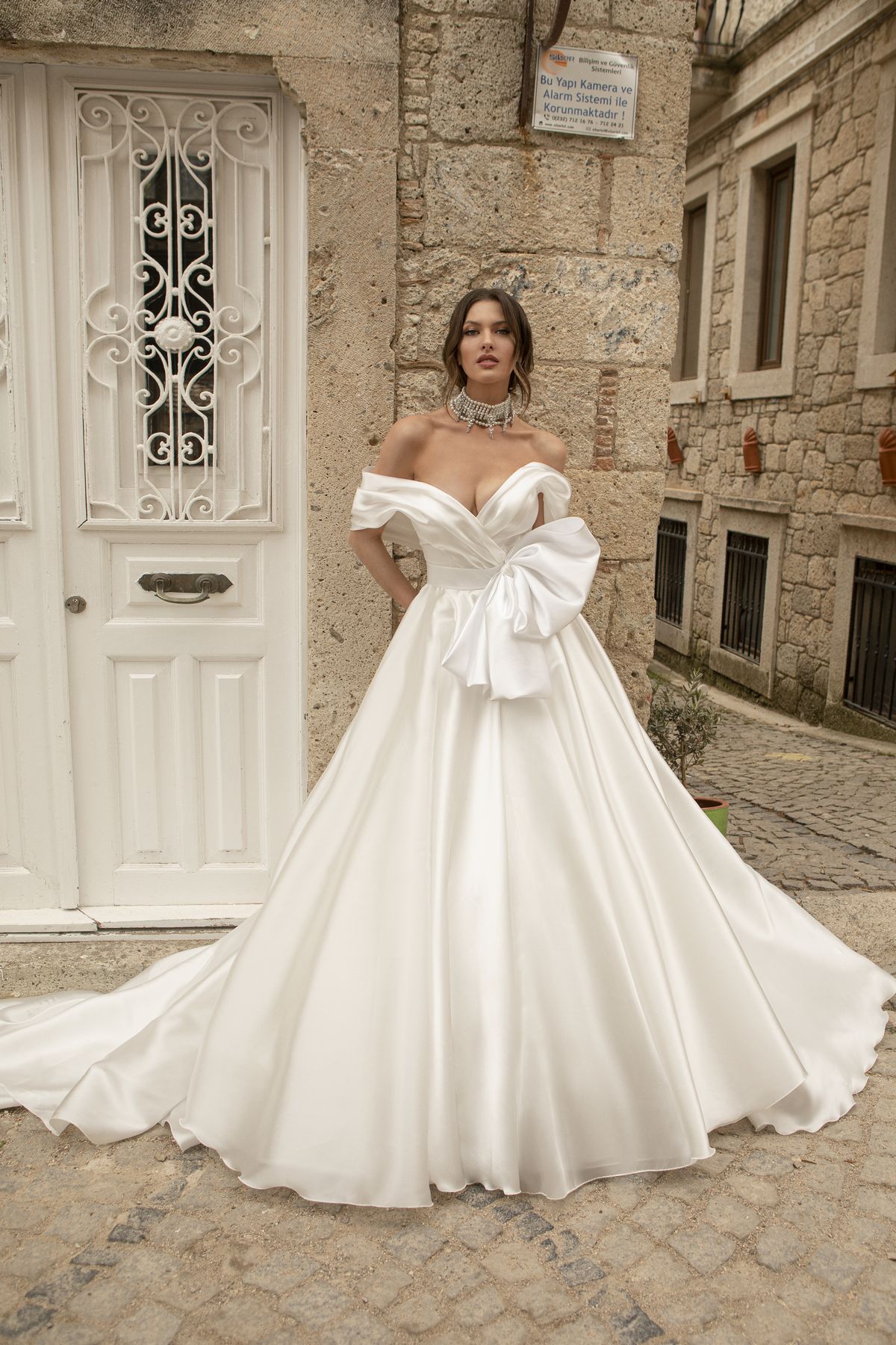 Satin white wedding gown Stella with a bow, off-shoulder sleeves and a-line skirt by Oksana Mukha designer 1