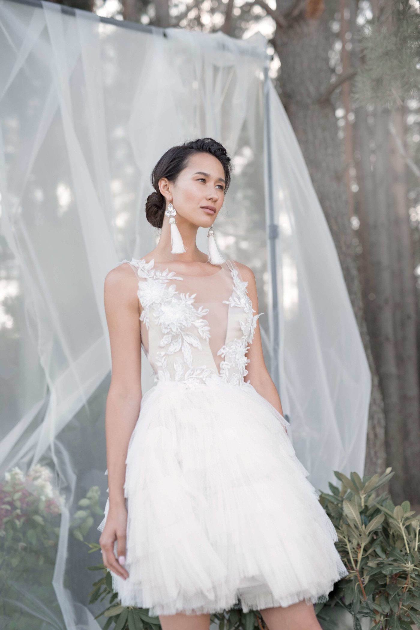 A bride wearing wedding dress with short skirt with horizontal flounces and lace bodice decorated with volume flowers by Rara Avis at Dell'Amore Bridal, Auckland, NZ. 4