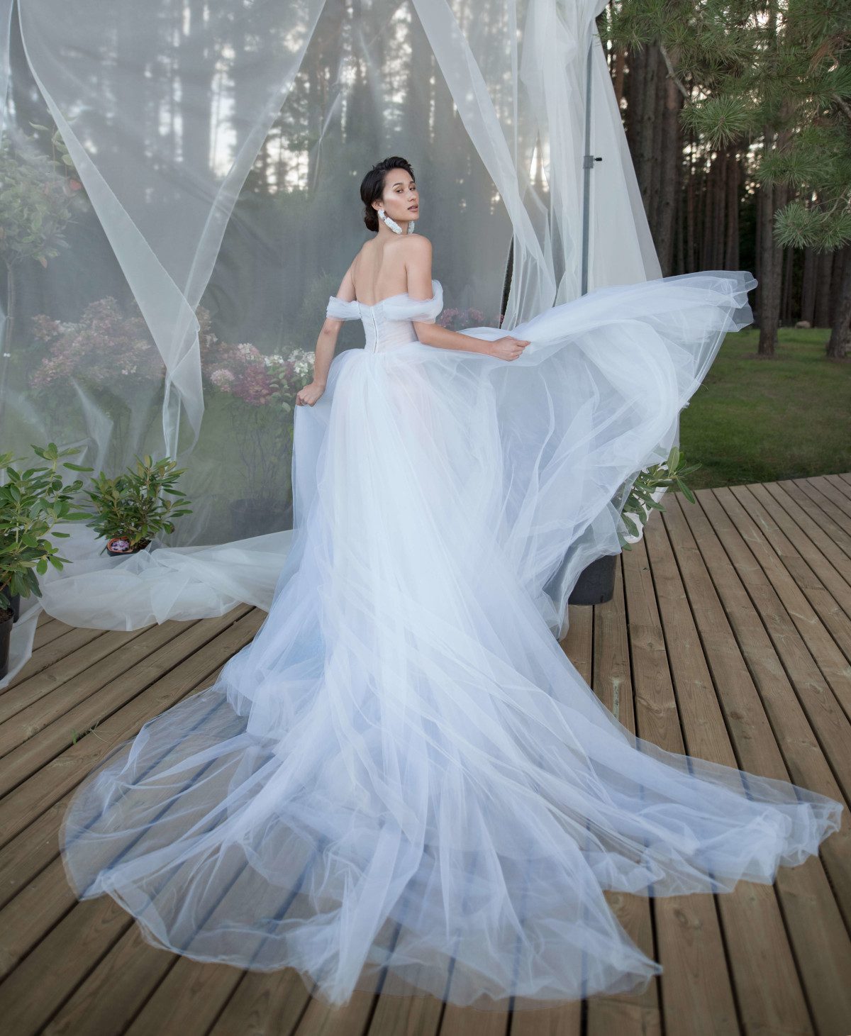 A bride wearing wedding dress with a long train, skirt decorated with lace elements and bodice decorated with beads and stones by Rara Avis at Dell'Amore Bridal, Auckland, NZ. 2