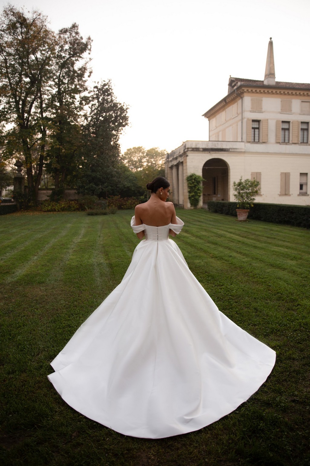 Off-shoulder satin wedding dress Shedar with wrap-over drapery corset by rara avis at Dell'Amore Bridal, NZ. 4