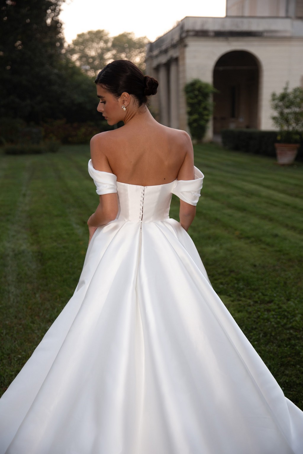 Off-shoulder satin wedding dress Shedar with wrap-over drapery corset by rara avis at Dell'Amore Bridal, NZ. 3