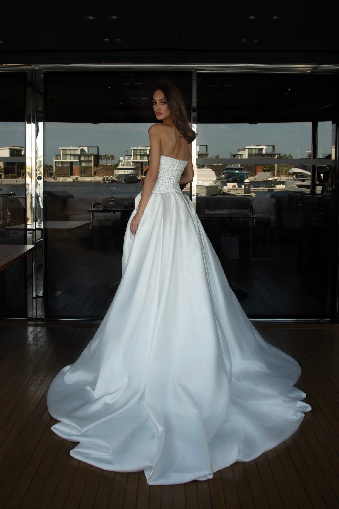 Flower draping wedding dress Harris with glittery corset and slit in the skirt by patricia couture at Dell'Amore Bridal, NZ.